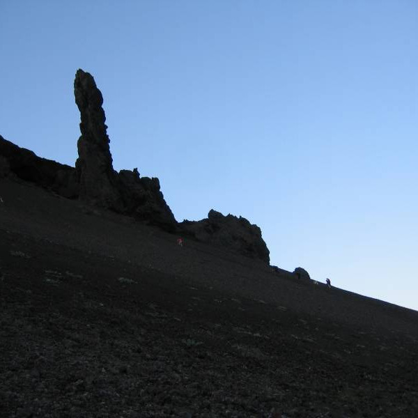 Hluti hópsins að klöngrast upp bratta skriðu neðan við mikla hraundranga.