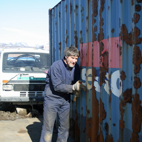 Brynleifur að ryðhreinsa gáminn fyrir grunnmálningu.