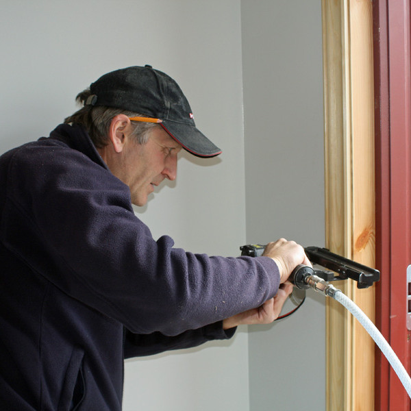 Sigurgeir að festa geretti við útihurð.