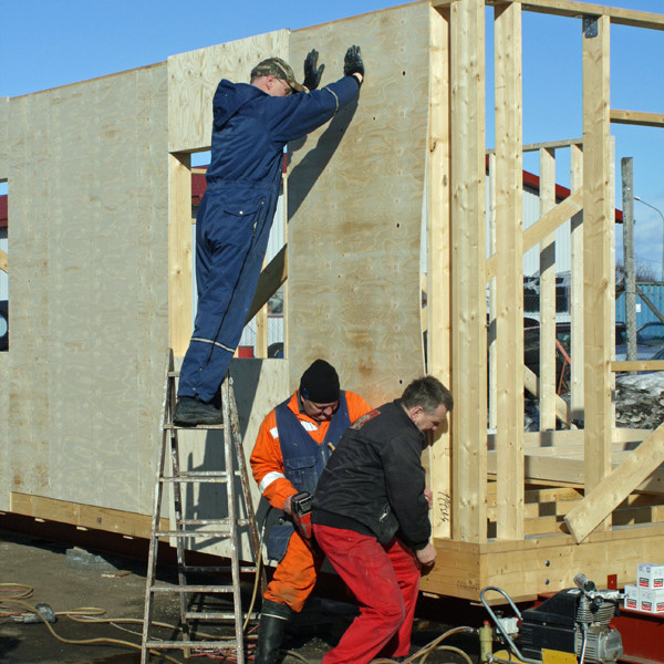 Krossviður settur á annan langvegg skálans.