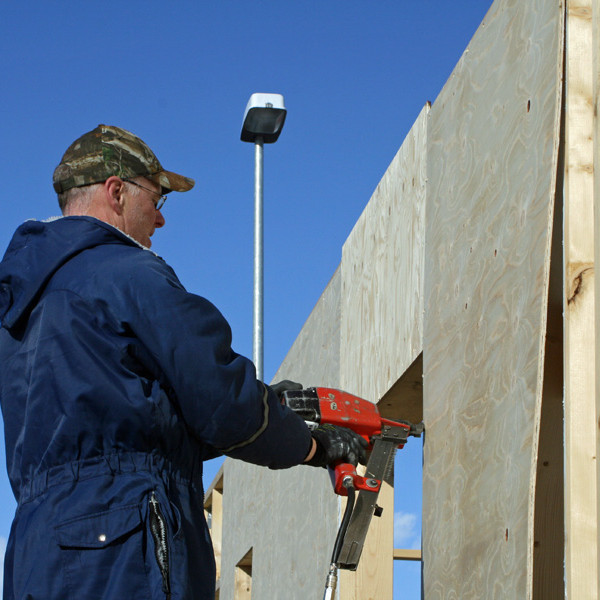 Vignir að festa krossvið með naglabyssu.