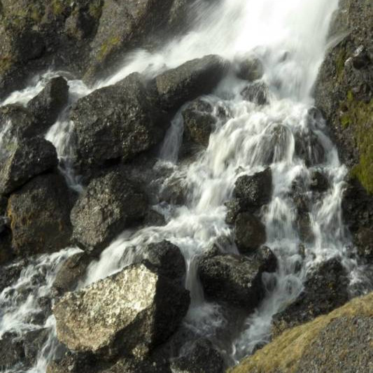 Lækur tifar létt við máða steina.