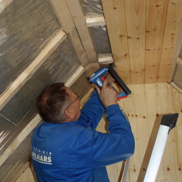 Hilmar að festa panelfjöl með heftibyssu.