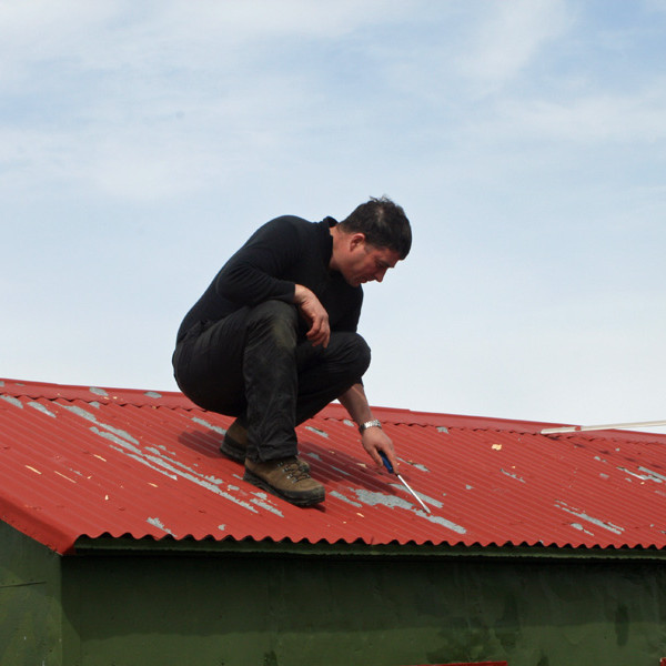 Stefán Stefánsson að undirbúa þak Lamba fyrir málningu.