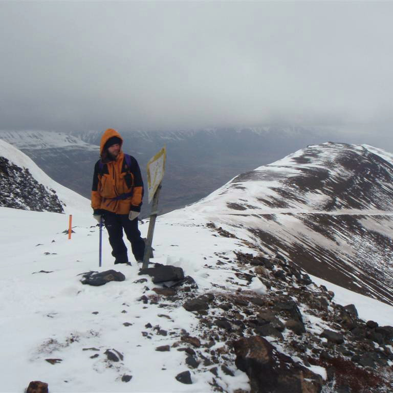 Séð til norðurs út yfir fjallsranann, snjór í vegsneiðingnum t.h.