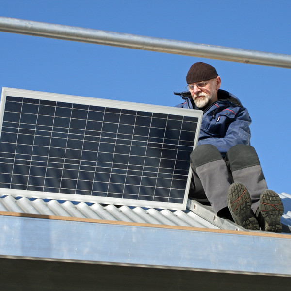 Ólafur Tr. Kjartansson að festa sólsellupanel á þak forstofunnar.