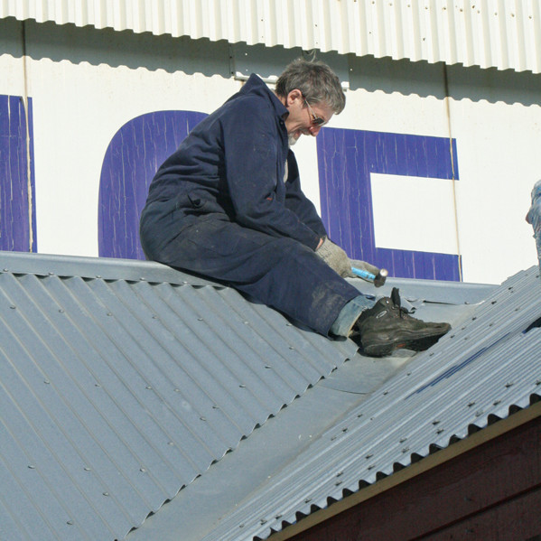 Brynleifur að hamra kjöl á þaki meginskálans.