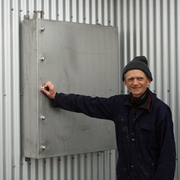 Grétar Grímsson við nýja olíutankinn utan á skálanum.