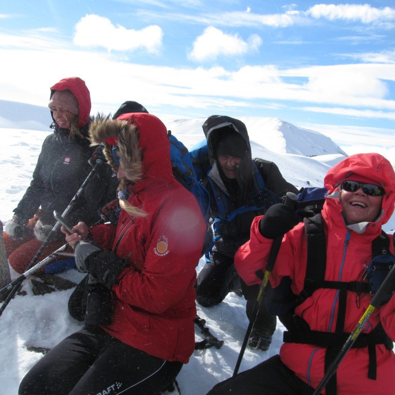 Á hnjánum á toppnum sökum mikils vinds.