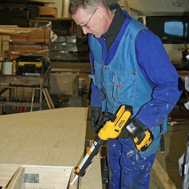 Hjalti Jóhannesson að kítta á veggeiningu undir krossvið.