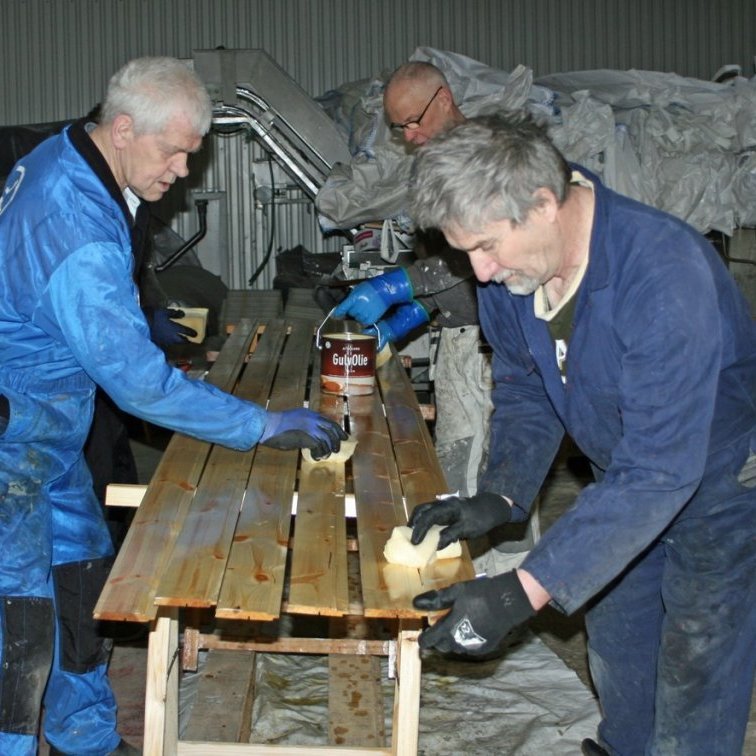 Garðar, Vignir og Brynleifur að bera olíu á panelfjalir með svampi.