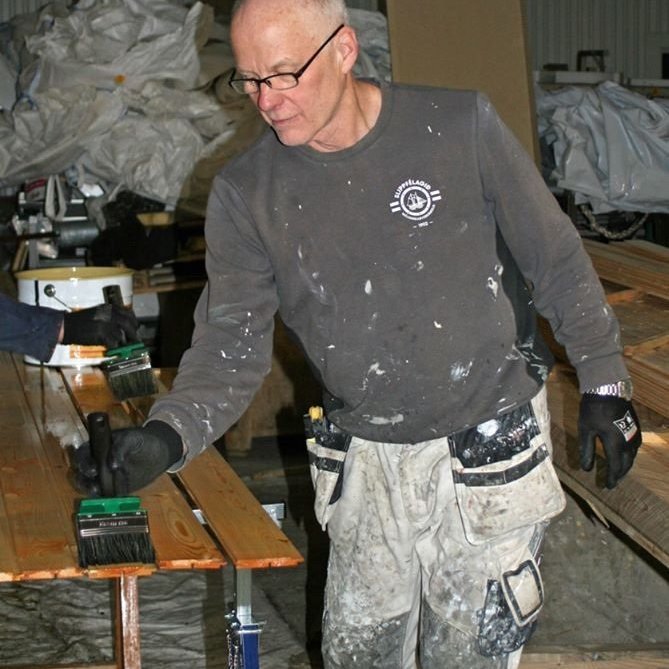 Vignir Víkingsson að bera lokaumferð af olíu á panelfjalir.