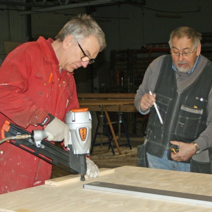 Grímur Laxdal að negla krossvið á veggjareiningu í nýja þjónustuhúsið. Hilmar byggingarstjóri fylgist með.