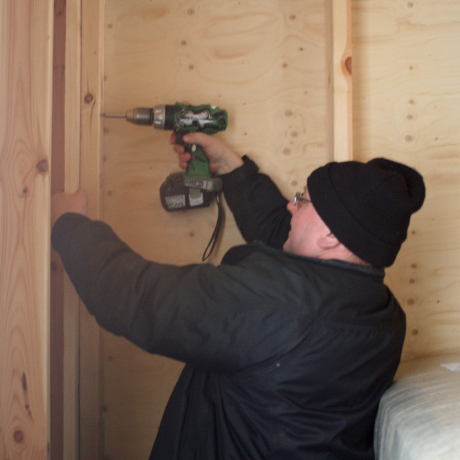 Þorvaldur Kristjánss að festa borð í horn skálans.