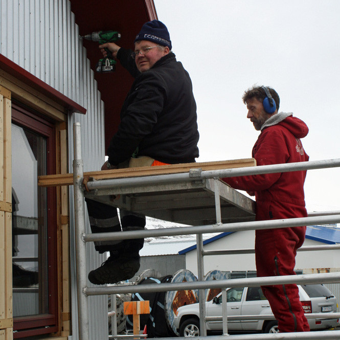 Árni Gísla að skrúfa aluzink plötu á stafn skálans. Frímann fylgist með.