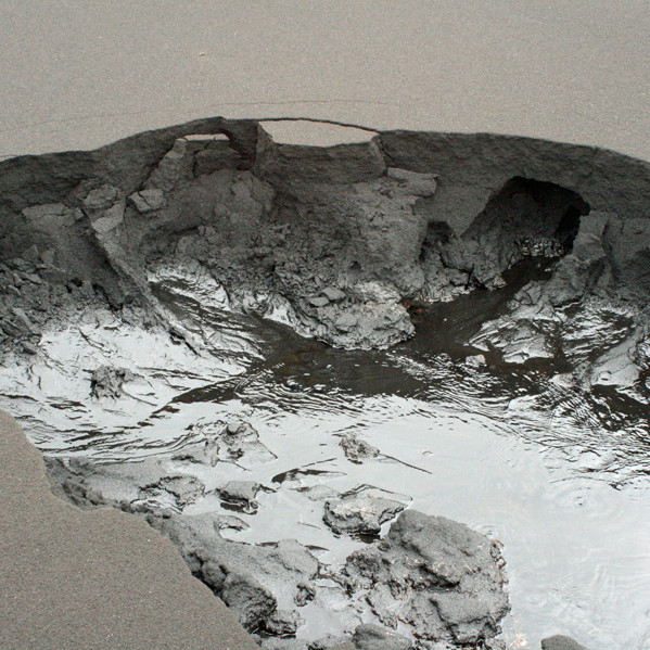 Ein af upptakalindum Svartár við Vaðöldu bullar fram undan svörtum sandinum.